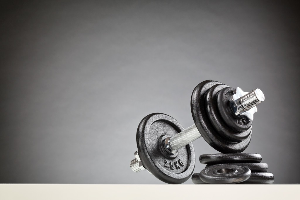 Bodybuilding or fitness equipment - a dumbbell resting on a stack of black weight discs.